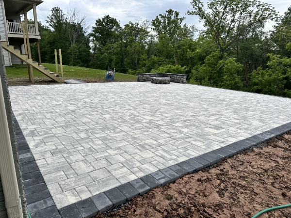 Expertly designed front walkway with decorative pavers and lush garden landscaping