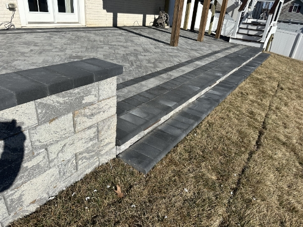 Professional paver walkway installation leading to elegant garden entrance with decorative edging